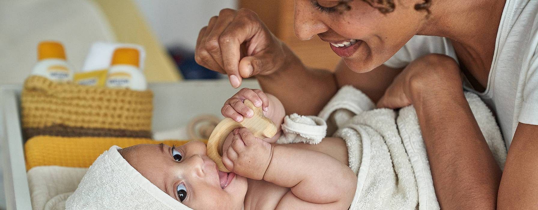 Mamma leker med baby på skjenkebord.