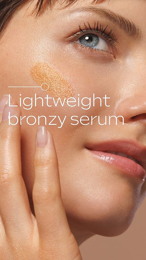 Tjej håller upp Weleda Sunkissed Bronzing Serum Drops mot ansikte