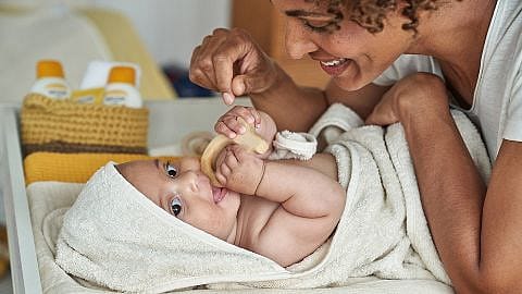 Mamma leker med baby på skjenkebord.